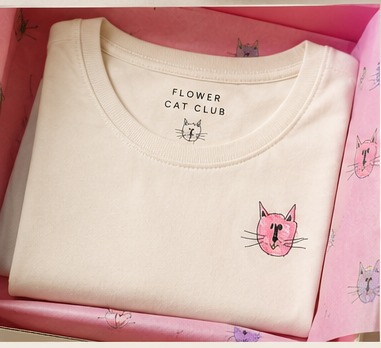 The ivory Founding Tee folded inside the box on printed tissue paper
